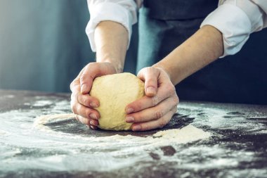 Siyah önlük Şef pizza hamuru ellerini masaya sağlar.