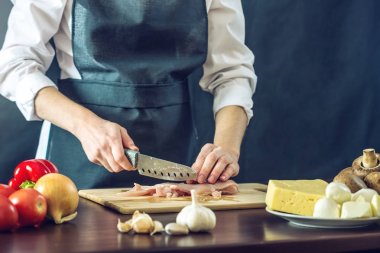 Siyah önlük Şef tavuk fileto bıçağı keser. Yemek pişirmek için çevre dostu ürünler kavramı