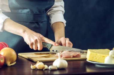 Siyah önlük Şef tavuk fileto bıçağı keser. Yemek pişirmek için çevre dostu ürünler kavramı