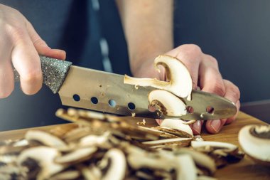 Siyah önlük Şef mantar bıçakla keser. Yemek pişirmek için çevre dostu ürünler kavramı