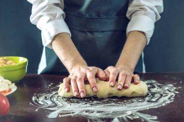 Siyah önlük Şef pizza hamuru ellerini masaya sağlar.