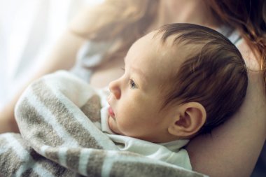 Yatak odasında erkek bebek tutan mutlu bakım anne. Annelik ve aile değerleri hassasiyet kavramı