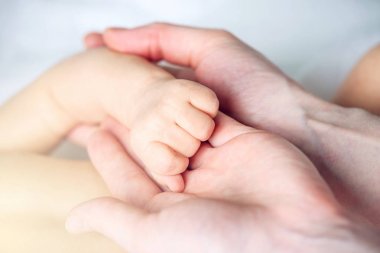 Bir bebeğin elini tutarak anne. Empati, güven, bakım ve hassasiyet annelik kavramı