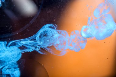 Beyaz swirls turuncu bir arka plan üzerinde duman gibi suda hareketli boya. Kavram arka plan