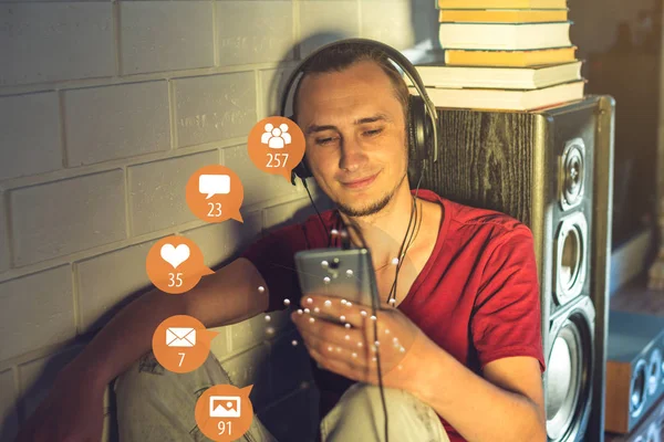 A young man uses the phone for entertainment and communication on the Internet and viewing notifications in the form of icons. The concept of social network and media