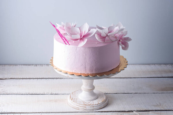 Beautiful pink wedding cake decorated with flowers. Concept of elegant holiday desserts