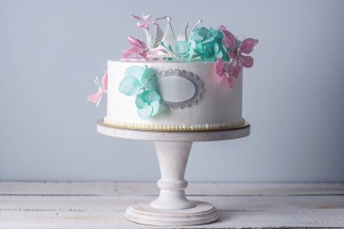 Güzel beyaz pasta pembe ve turkuaz çiçek ve bir prenses tacı dekore edilmiştir. Tatlı kızlar için kavramı