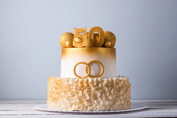 Bella torta per il cinquantesimo anniversario del matrimonio decorata con palline d'oro e anelli. Concetto di dessert festivi — Foto Stock