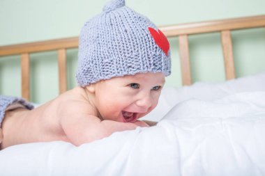 Mutlu bebek beşik üzerinde bir kalp ile örme bere bir battaniyeye yalan söylüyor. Annelik ve vahşi kavramı