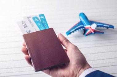 Passport uçak biletleri ile beyaz bir arka plan üzerinde tutan el. İş seyahat kavramı