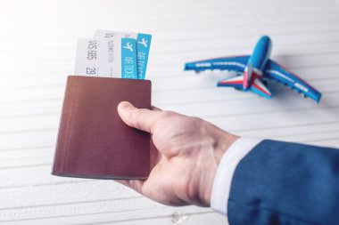 Passport uçak biletleri ile beyaz bir arka plan üzerinde tutan el. İş seyahat kavramı