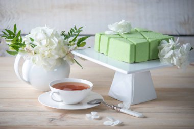 Çok güzel bir sabah düğün çay tablo raf ve beyaz ortancaları kare yeşil bir pasta ile.