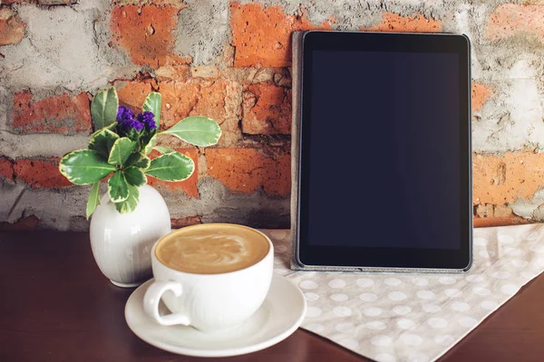 Bir fincan cappuccino kahve ile tablet. Yukarı alay.