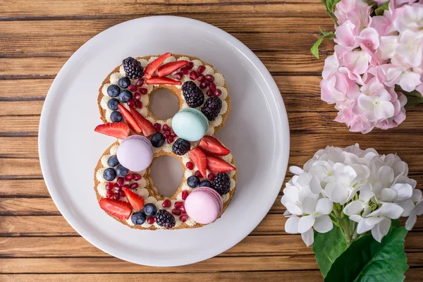 Pastel en forma de número 8 decorado con bayas y flores. Postre para el día de la mujer el 8 de marzo — Foto de Stock