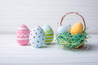 El boyalı bir beyaz ahşap arka plan üzerinde renkli Paskalya yumurta. Festival bahar kartı