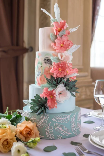 Inicio Boda para pastel por niveles sobre la mesa en el restaurante decorado con rosas rosadas y hojas verdes en un estilo rústico —  Fotos de Stock