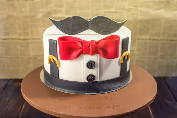 Beautiful cake for men, decorated in the form of a suit with a bow tie. Concept of the desserts for the birthday boy