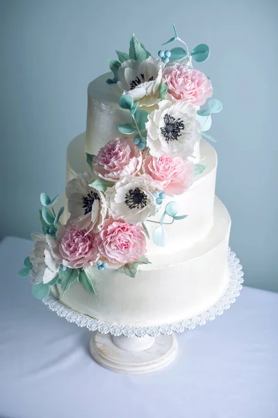 Hermosa torta de boda blanca de tres niveles decorada con flores de azúcar peonías rosadas. Concepto de elegantes postres navideños —  Fotos de Stock