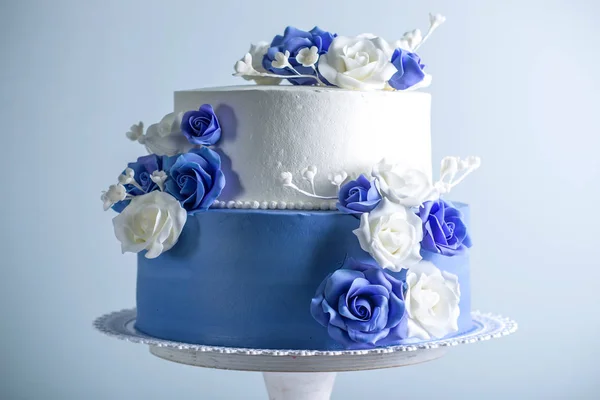 美丽的两个分层的白色和蓝色婚礼蛋糕装饰花糖玫瑰。优雅假日甜点概念 — 图库照片