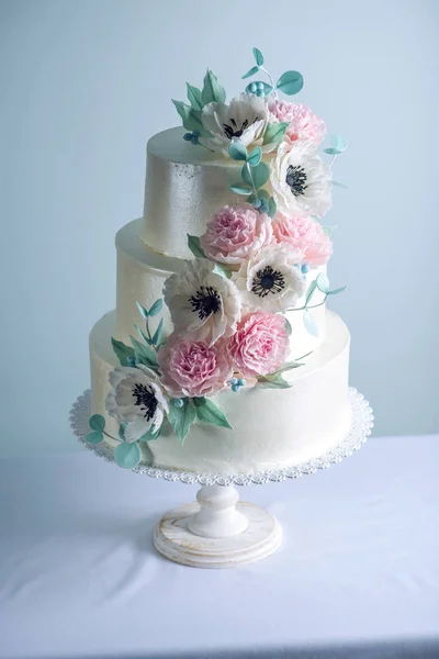 Hermosa torta de boda blanca de tres niveles decorada con flores de azúcar peonías rosadas. Concepto de elegantes postres navideños —  Fotos de Stock