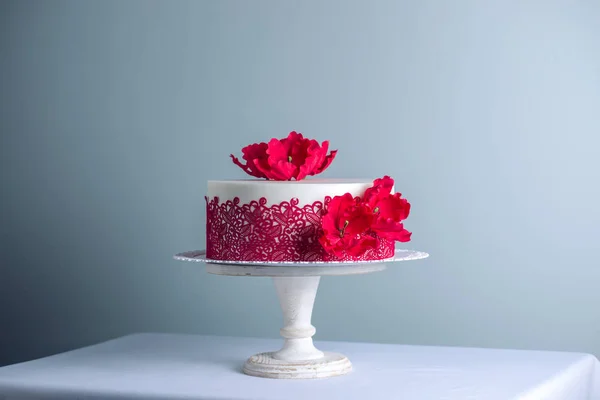 白色婚礼蛋糕装饰用花糖罂粟和红色图案装饰品。优雅假日甜点概念 — 图库照片