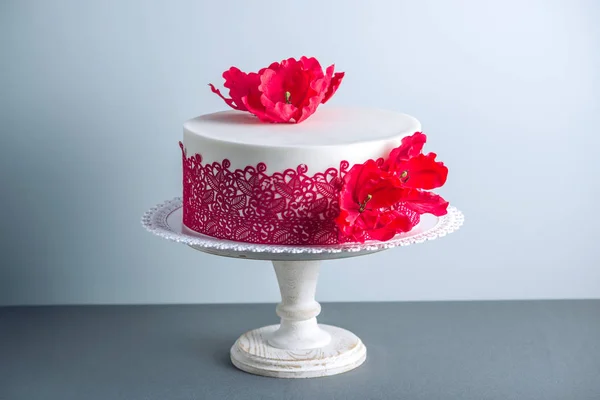 Bolo de casamento branco decorado com flores papoilas de açúcar e ornamento padrão vermelho. Conceito de sobremesas de férias elegantes — Fotografia de Stock