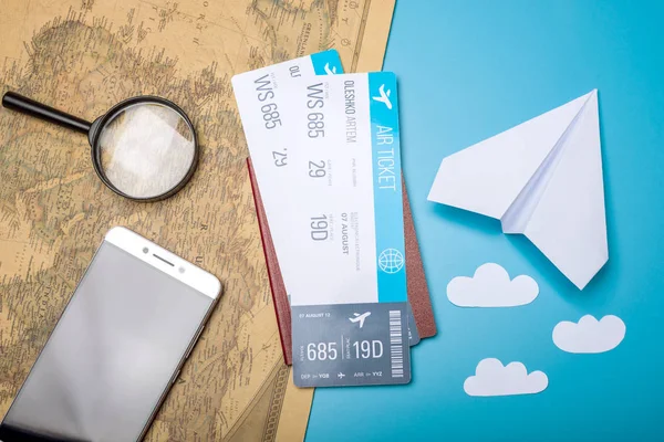 Billetes de avión con pasaporte y avión de papel en el fondo del mapa del mundo, vista superior. El concepto de viajes aéreos y vacaciones — Foto de Stock
