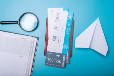 Mavi arka plan, TOPVIEW pasaport ve kağıt uçağa ile uçak bileti. Hava seyahat ve tatil kavramı