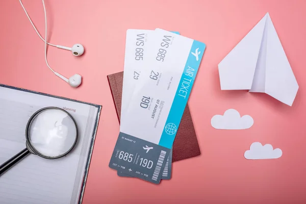 Billetes aéreos con pasaporte y avión de papel sobre fondo rosa, vista superior. El concepto de viajes aéreos y vacaciones — Foto de Stock