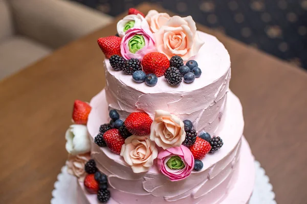 Pastel de boda rosa de tres niveles decorado con bayas y flores. Concepto pastelería florística de almáciga de azúcar —  Fotos de Stock