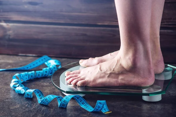 Female feet standing on electronic scales for weight control on dark background. Concept of sports training, diets — Stock Photo, Image