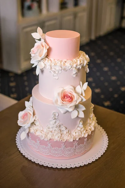 Прекрасний елегантний чотириярусний рожевий весільний торт, прикрашений квітами троянд. Концепт квітковий з цукрової мастики — стокове фото