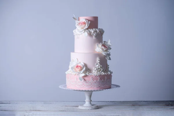 Schöne elegante vierstöckige rosa Hochzeitstorte mit Rosen Blumen verziert. Konzept blumig aus Zuckermastix — Stockfoto