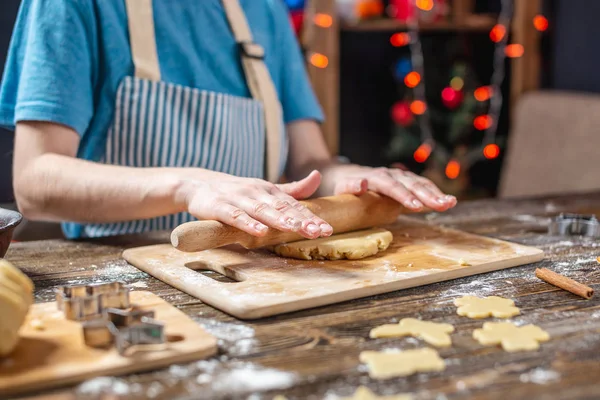 Kadın hamuru oklavayla yuvarlıyor ve şenlikli zencefilli ekmeği şekillendiriyor. Noel zamanı lezzetli kurabiyeler pişirmek. — Stok fotoğraf