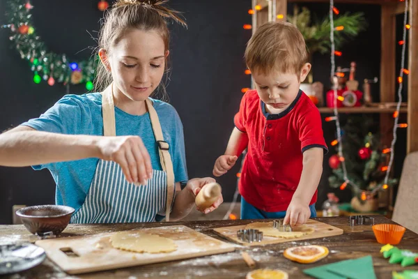 Mom and child son shape the dough for baking homemade holiday gingerbread. Family cooking in Christmas decorations — Stock Photo, Image