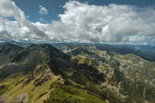 Majestic θέα του τοπίου από την κορυφή προς τα βουνά στα σύννεφα σε μια ηλιόλουστη μέρα το καλοκαίρι — Φωτογραφία Αρχείου