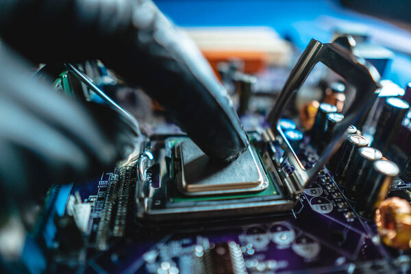 Инженер-ремонтник держит за руки процессор для вставки в гнездо