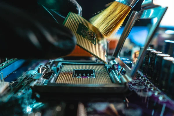 Insinyur memegang tangan CPU untuk dimasukkan ke dalam soket motherboard. Teknologi hardware dan perbaikan dalam cahaya neon — Stok Foto