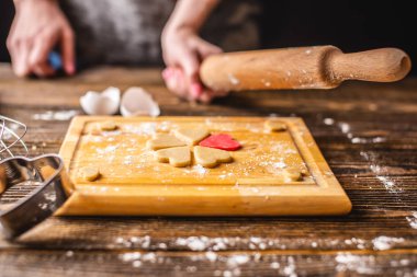 Kalp şeklinde hamurdan kurabiye pişirmek. Sevgililer Günü için yemek ve romantik bir randevu.