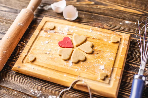 Cozinhar biscoitos da massa em forma de coração. Cozimento para o dia dos namorados e uma data romântica — Fotografia de Stock