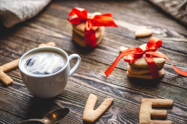 Bir fincan kahve ve sevgi şeklinde tatlı bir kurabiyeden bir mesaj. Romantik Sevgililer Günü hediyesi