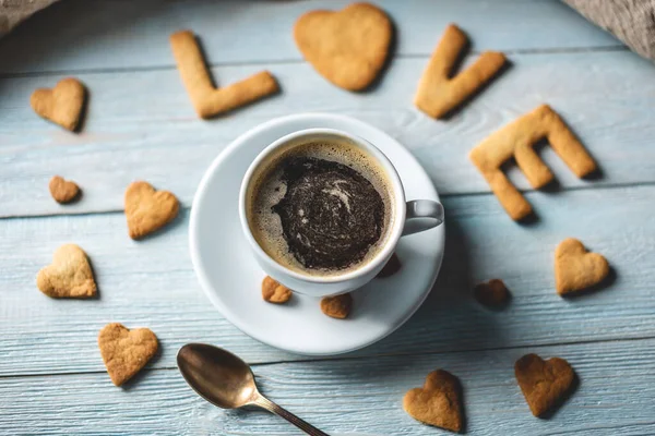 Copo de café e uma mensagem de um biscoito doce na forma da palavra amor. Presente romântico do dia dos namorados — Fotografia de Stock