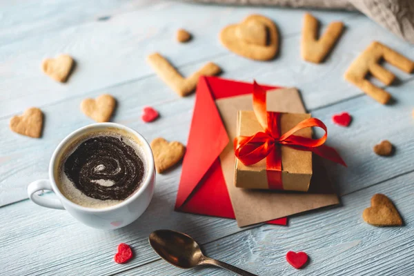 Copo de café e uma mensagem de um biscoito doce na forma da palavra amor. Presente romântico do dia dos namorados — Fotografia de Stock