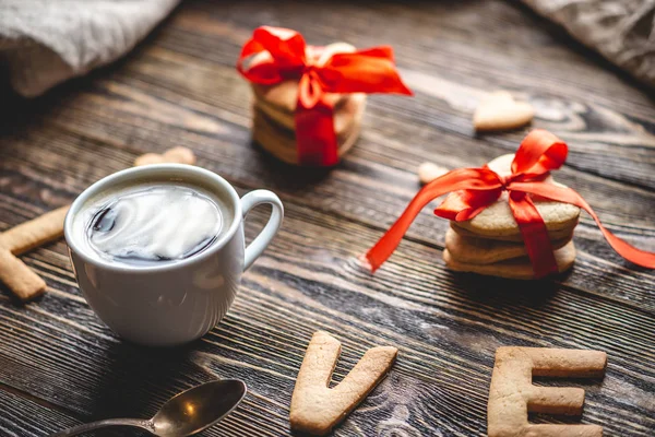 Cup of coffee and a message from a sweet cookie in the form of the word love. Romantic Valentine's day gift — Stok Foto
