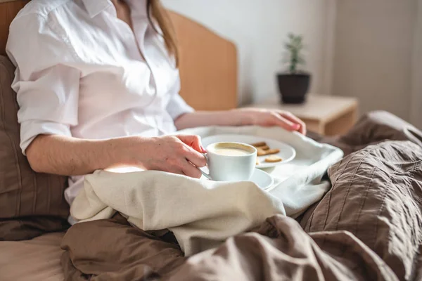 stock image Woman have a romantic Breakfast in cozy morning bed. Coffee and word love from cookies. Surprise on Valentine's day