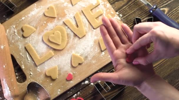 Gotowanie ciasteczek z ciasta w kształcie serca i słowa miłość. Pieczenie na Walentynki i romantyczna randka — Wideo stockowe