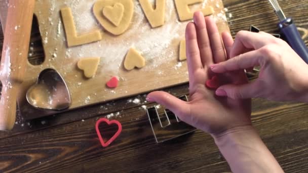 Sütit sütni a tésztából szív alakban, és a szerelem szó. Sütés Valentin nap és egy romantikus dátum — Stock videók