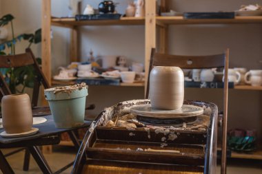 Potter çarklı bir çömlek atölyesi ve kilden yapılmış bir vazo.