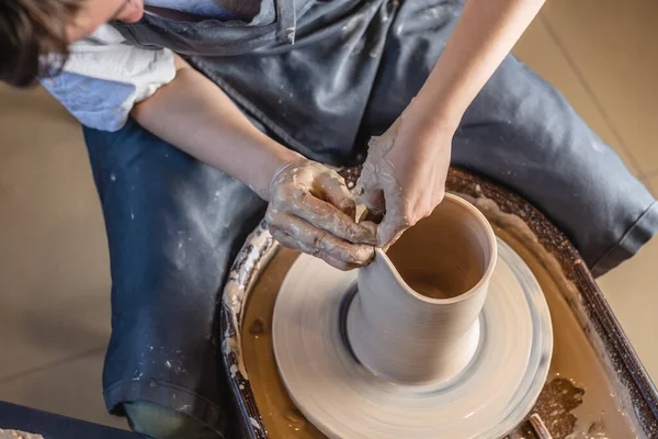 Potter 'ın çarkında vazo yapan kadın çömlekçi. Usta elleriyle kil oluşturuyor atölyede sürahi yapıyor. — Stok fotoğraf