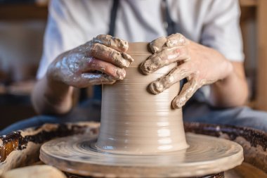 Potter, Potter 'ın çarkında vazo yapıyor. Kadın, bir atölyede sürahi yaratarak kilin şeklini alıyor. Kapat.